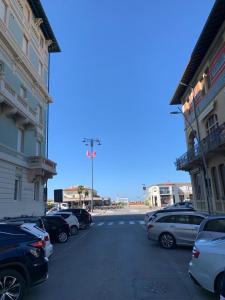 un parking avec des voitures garées à côté des bâtiments dans l'établissement loft flavia, à Viareggio