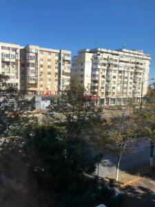 a large apartment building with trees in front of it at Adrian Home, Central in Ploieşti