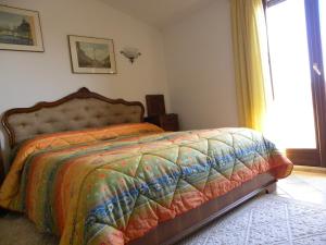 フィアーノ・ロマーノにあるB&B Al Laghettoのベッドルーム(カラフルなキルトのベッド付)