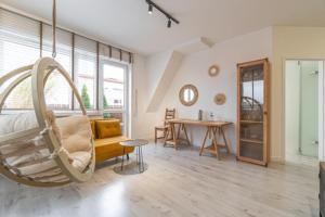 een woonkamer met een schommelstoel en een tafel bij Apartament Centrum III in Bydgoszcz