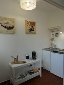 een keuken met een wit aanrecht en een wastafel bij Studio au coeur de Saint Quentin en Yvelines in Trappes