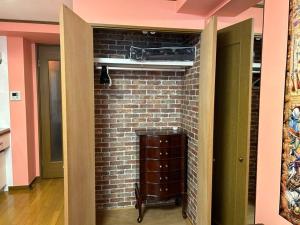 a room with a brick wall with a vent at ラフォレ１０２　新宿から13分のくつろげるお部屋 in Tokyo