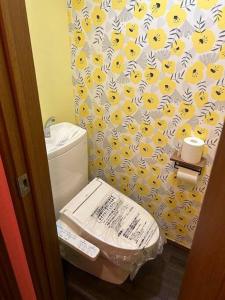 a bathroom with a toilet with a yellow and white shower curtain at ラフォレ１０２　新宿から13分のくつろげるお部屋 in Tokyo