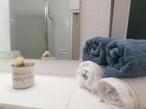 a bathroom with towels on a counter in front of a mirror at Casa cu trandafiri in Baia Mare