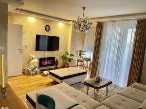 uma sala de estar com um sofá e uma televisão em Plaza extra lux apartman garage free em Stanovo