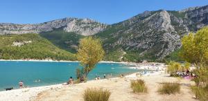 a group of people on a beach with mountains in the background at Appartement T2 imm. La Villa d'Este in Digne-les-Bains