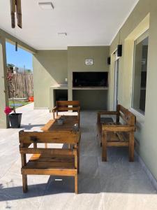 three wooden benches sitting outside of a building at casa quinta caballito blanco in Chascomús +4 photos