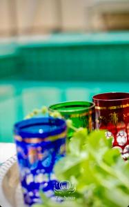 three blue and red cups sitting on a plate at Riad Zouhour in Marrakech