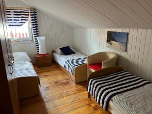 ein kleines Zimmer mit zwei Betten und einem Stuhl in der Unterkunft Rowianka in Rowy