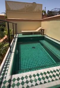 a swimming pool in a house with a tile floor at Riad Zouhour in Marrakech