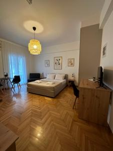 Schlafzimmer mit einem Bett und Holzboden in der Unterkunft Cozy Faliro home in Piräus