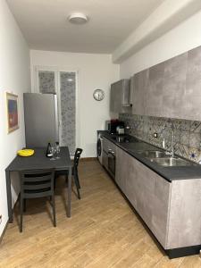 a kitchen with a table and a sink and a counter at SAMMARTINO LUXURY APARTMENT in Palermo