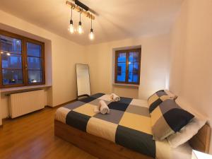 a bedroom with a bed with two stuffed animals on it at ElvesHome - Alpine Stay Apartments in Predazzo