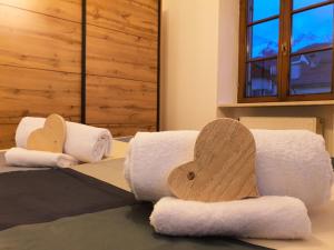 a room with three towels and a wooden heart at ElvesHome - Alpine Stay Apartments in Predazzo