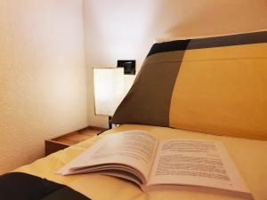 an open book sitting on top of a bed at ElvesHome - Alpine Stay Apartments in Predazzo