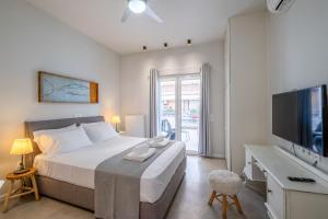 a bedroom with a large bed and a television at Central5 Boutique Apartments with Common Garden Next to Metro in Athens