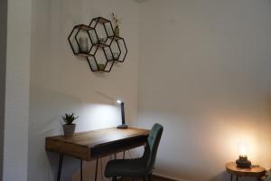 een bureau met een lamp en een stoel naast een muur bij Design-Apartment I Boxspring I Nespresso I Parkplatz in Bad Krozingen