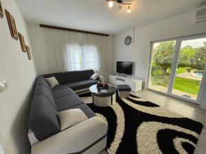 uma sala de estar com um sofá e uma televisão em Sunny Apartment with swimming pool Stolac em Stolac