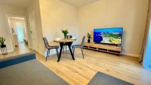 a living room with a table and a flat screen tv at Apartament GREEN CROWNS in Płock