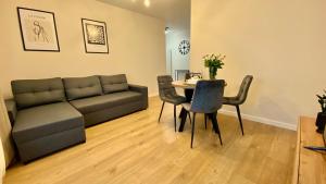 a living room with a couch and a table at Apartament GREEN CROWNS in Płock