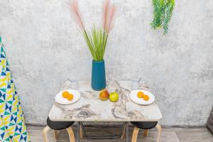 une table avec des assiettes de fruits et un vase dans l'établissement YourHouse на Си Синхая 22 близко к Меге, à Almaty