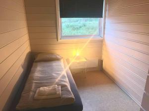 a small room with a bed and a window at Apartment-B near Etne-Odda in Etnesjøen