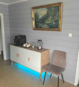 Cette chambre comprend une armoire, une chaise et un miroir. dans l'établissement Apartment-B near Etne-Odda, à Etnesjøen