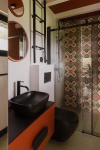 baño con lavabo negro y aseo en laba, en Lasowka