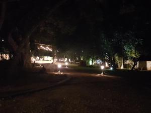 eine dunkle Straße in der Nacht mit Lichtern auf der Straße in der Unterkunft Eighth Wonder Resort in Sigiriya
