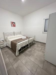 um quarto com uma cama e piso em azulejo em VILLA MARINA em Porto Cesareo