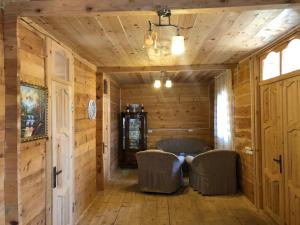 ゼクヒズジョリにあるJoni's Cottageの木製の壁と籐の椅子が備わる客室です。