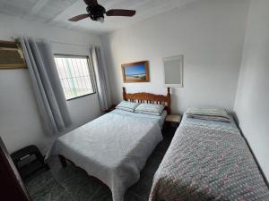a bedroom with two beds and a window at Casa Verão de Itaúna in Saquarema
