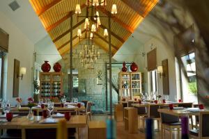 a restaurant with tables and chairs and a chandelier at Madre de Água Hotel Rural de Charme in Gouveia