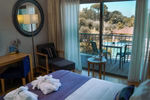 a bedroom with a bed and a view of a balcony at Madre de Água Hotel Rural de Charme in Gouveia