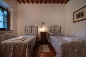 a bedroom with two beds and a table and a window at Ca Nova Sud in Siena