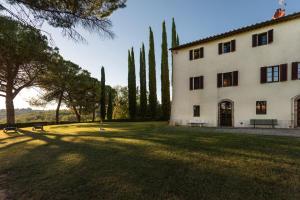 Un gran edificio blanco con árboles y un patio con césped. en Ca Nova Sud, en Siena