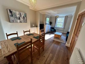 a dining room and living room with a wooden table at 2 Bedroom Home Full Of Character in Nantwich