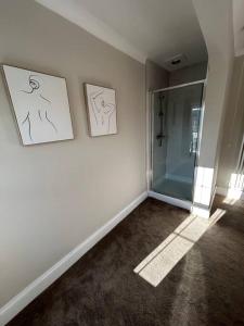 a room with a shower and two pictures on the wall at 2 Bedroom Home Full Of Character in Nantwich +19 photos