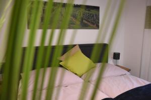 a bed with a yellow pillow and a green curtain at Wein & Wohnen MATZL - Ferienwohnung in Fürstenfeld