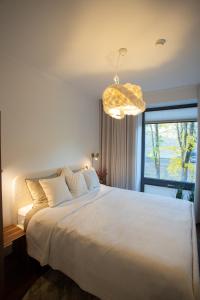 ein Schlafzimmer mit einem großen weißen Bett und einem Fenster in der Unterkunft Tatari 16 City Centre New Apartment in Tallinn