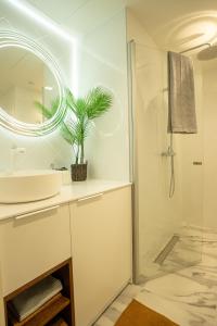 ein Badezimmer mit einem Waschbecken und einer Dusche mit einer Pflanze in der Unterkunft Tatari 16 City Centre New Apartment in Tallinn