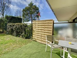 a patio with a table and chairs and a fence at Le Phare in Royan