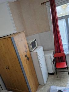 a small kitchen with a microwave on top of a refrigerator at Le nid in La Bourboule