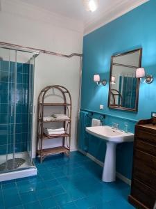 a blue bathroom with a sink and a shower at La Stazione di Posta in Cassino