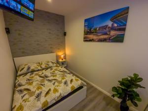 a bedroom with a bed and a tv on the wall at Punkt - Apartamenty z jacuzzi w centrum Katowic in Katowice