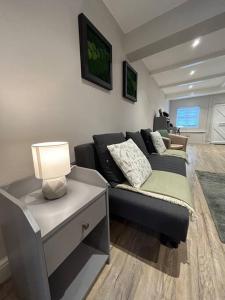 a living room with a couch and a table with a lamp at Brand New Cosy 1 Bedroom Home in Nantwich