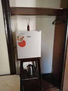 a refrigerator on a stand with a pot on top at Coralca in Martínez