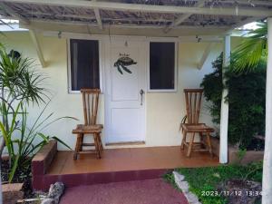 a house with two chairs and a white door at Arena Oceanview Hotel & La Terraza Restaurant in Las Galeras