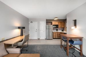 an open living room with a desk and a kitchen at Residence Inn Springfield in Springfield