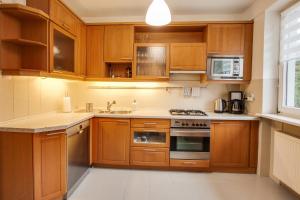 a kitchen with wooden cabinets and stainless steel appliances at Willa Bliski in Szczyrk